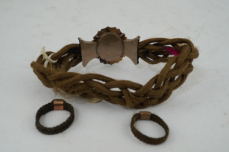 A Victorian yellow metal mounted plaited hair bracelet and two similar rings. Condition - poor